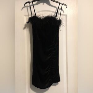 Shimmery black velvet party dress with feather embellishment.